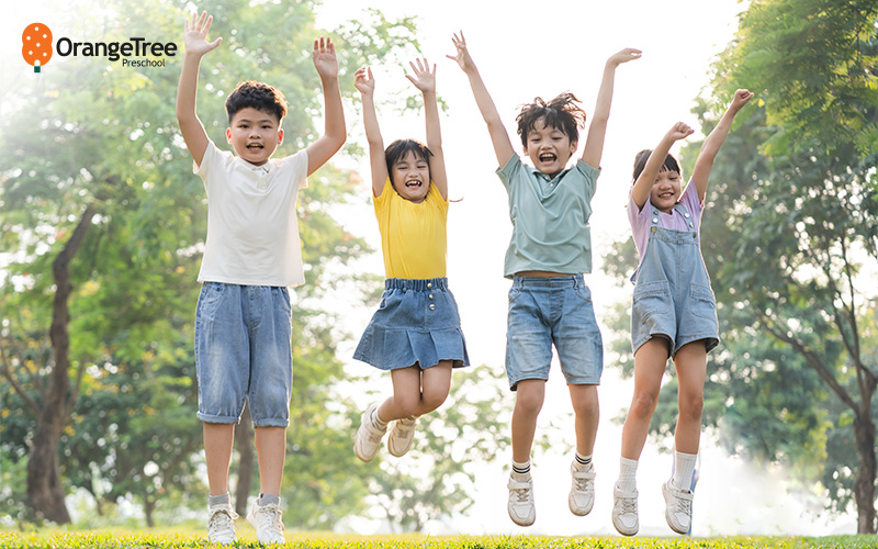A group of children jumping in unison outdoors 