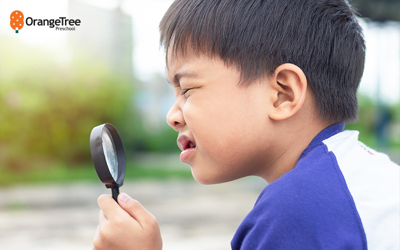 Child exploring with a magnifying glass.