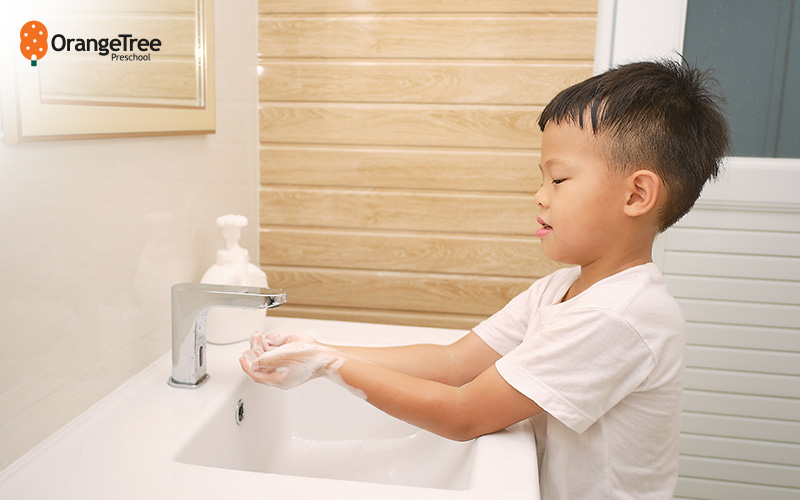 Child washing hands, teaching good daily hygiene routines.