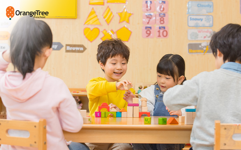 Children playing with colorful wooden blocks in class.