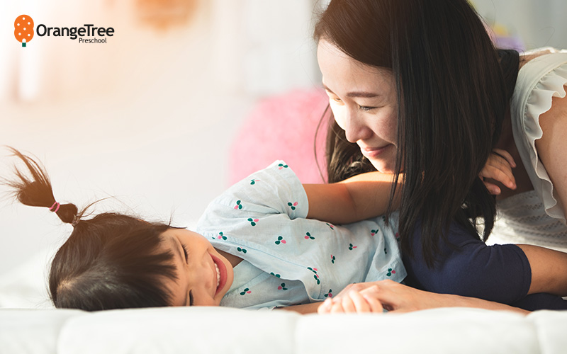 Mother waking up child, highlighting positive parenting for preschool.