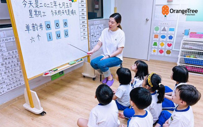 OrangeTree Preschool teacher guiding children in a class.