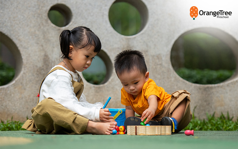 Preschoolers engaged in outdoor play with toys.