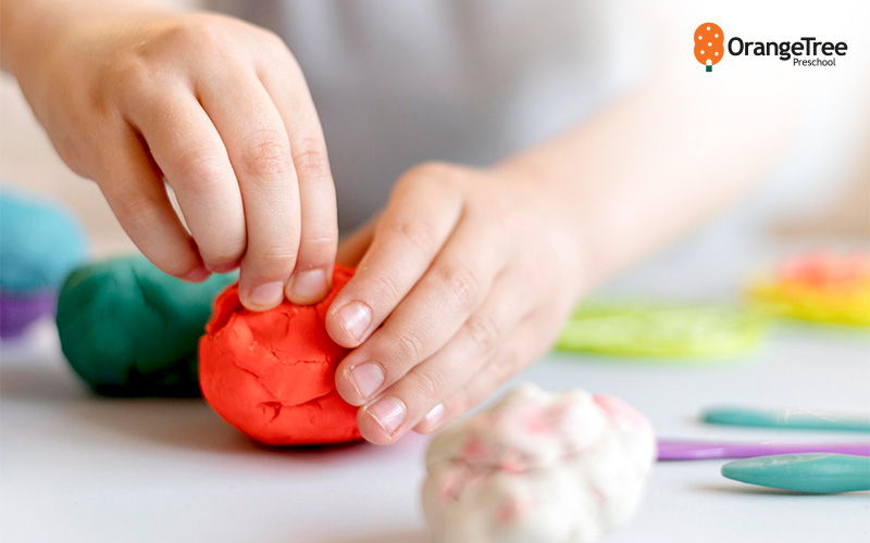 child playing with playdoh in class
